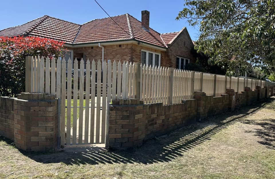 Windsor style timber picket fence and gate built on the original brick plinth of a 1930s brick cottage